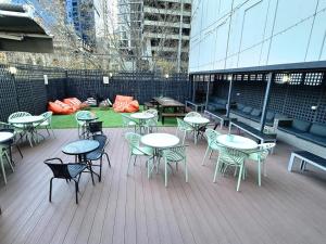a deck with tables and chairs on a building at Europa Melbourne in Melbourne