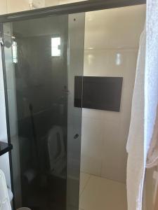 a glass shower in a bathroom with a toilet at Apartamento da Pâm - em frente ao clube cantão in Pontes e Lacerda +3 photos