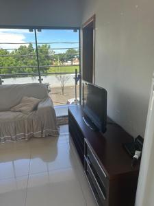 a bedroom with a bed and a television on a dresser at Apartamento da Pâm - em frente ao clube cantão in Pontes e Lacerda