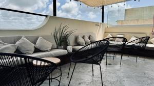 a group of chairs and a couch on a patio at Hotel Noah Tulum in Tulum