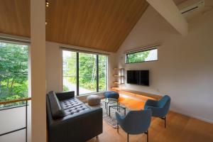 a living room with a couch and chairs and a tv at Kihaku in Kutchan