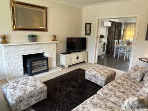 a living room with a fireplace and a tv at Cambridge Cottage - Self Catering Holiday House in Cambridge