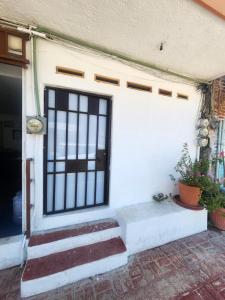 a front door of a house with stairs and plants at Casa Lao Bungalow in Zihuatanejo