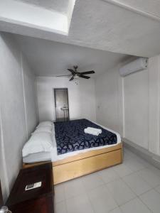 a bedroom with a bed with a ceiling fan at Casa Lao Bungalow in Zihuatanejo