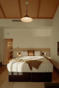 a bedroom with a large white bed with a ceiling at Drifter Christchurch in Christchurch