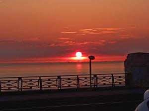 a sunset over the ocean with a fence at North Ocean Hotel in Blackpool