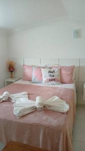a bed with two white towels and a bow on it at Loft Outono Centro Histórico in Paraty