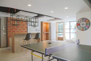 una mesa de ping pong en una habitación con sillas en GOYA Suites y Comfort, en Quito