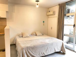 San Telmo y Caminito para 1 a 4 personas في بوينس آيرس: غرفة نوم مع سرير في غرفة مع نافذة