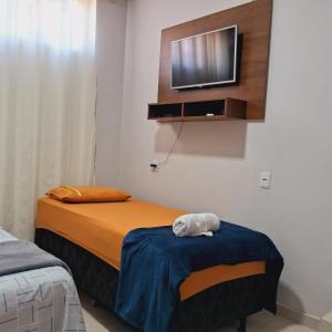 um quarto com uma cama e uma televisão na parede em Flat ideal para familia e grupos de amigos proximo ao aeroporto e rodoviária em Palmas