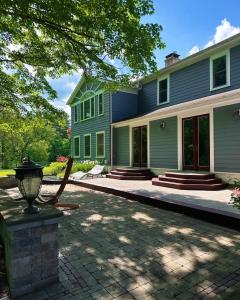 uma casa verde com uma entrada de tijolos em frente em 37 Oak Ridge House em Wellsboro