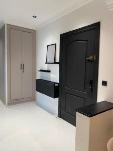 Cette chambre est dotée d'une porte noire et d'un mur blanc. dans l'établissement RABAT RESIDENCE - rooms, à Rabat