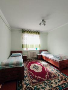una camera con due letti e un tappeto di Guest house Kyzyl alma a Arkit