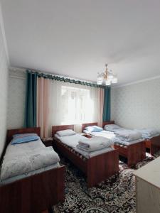una camera con tre letti e una finestra di Guest house Kyzyl alma a Arkit