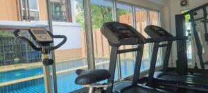 a gym with two treadmills and a swimming pool at 1 Double bedroom Apartment with Swimming pool security and high speed WiFi in Udon Thani