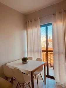 a white table and chairs in a room with a window at Studio 208 Praia de Iracema in Fortaleza +6 photos