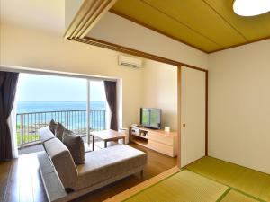 a living room with a couch and a television at Wellness Villa Brisa in Miyako-jima