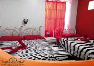 two beds sitting next to each other in a bedroom at HOSTAL VILLA.REAL in Quito