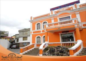 an orange building with stairs in front of it at HOSTAL VILLA.REAL in Quito