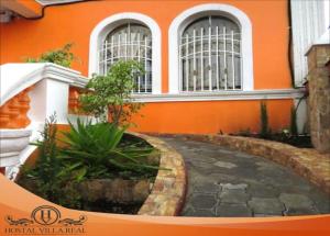 an orange building with a walkway in front of it at HOSTAL VILLA.REAL in Quito