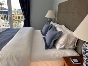 1 dormitorio con cama con almohadas y ventana en The Boat House Studio, en Tairua