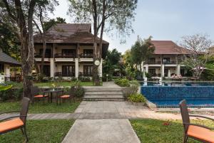 ośrodek z basenem i domem w obiekcie Lanna Dusita Riverside Boutique Resort w mieście Chiang Mai