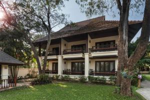 a house with trees in front of it at Lanna Dusita Riverside Boutique Resort in Chiang Mai