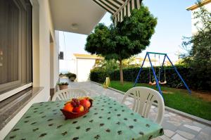a table with a bowl of fruit and a swing at Apartments Ivan in Duće