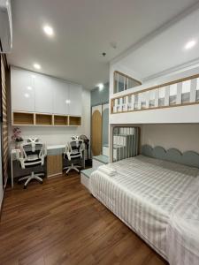 a bedroom with a bunk bed with a desk and two chairs at Serviced Green Pearl Apartment in Bac Ninh city in Hòa Ðình