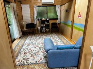 小国町にあるnanakoyaのリビングルーム(青いソファ、ラグ付)