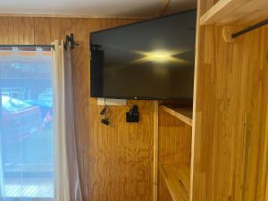 a flat screen tv hanging on a wall with a window at Hostal Español Coyhaique in Coihaique