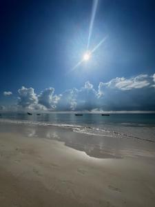vistas a una playa con el sol en el cielo en El Paraiso Hotel Tulum, en Tulum