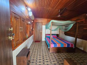 Un pequeño dormitorio con una cama en una habitación de madera. en Eco village beach resort, en Pottuvil