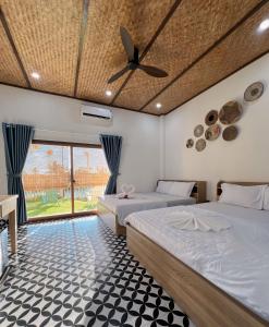 ein Schlafzimmer mit zwei Betten und einem Deckenventilator in der Unterkunft Homestay Phú Mỹ in Phan Thiet