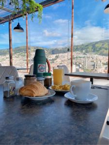 a table with a plate of bread and a cup of coffee at Hostal La Terraza in Quito