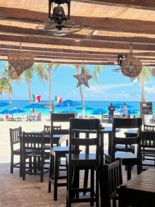 a restaurant with tables and chairs on the beach at El Paraiso Hotel Tulum in Tulum