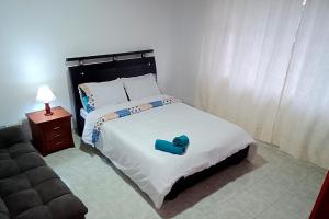 Un dormitorio con una cama grande con un objeto azul. en Casa Corferias, en Bogotá