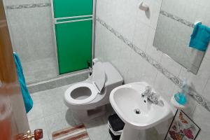 uma casa de banho com um WC branco e um lavatório. em Casa Corferias em Bogotá
