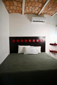 サユリタにあるCasa Baluana vive Sayulita a un paso de todoのベッドルーム1室(大型ベッド1台、黒いヘッドボード付) +6枚の写真