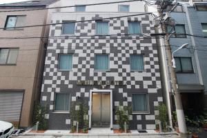 東京的住宿－MARUKOU HOTEL，上面有校对板图案的建筑