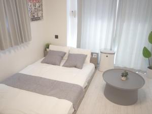 um quarto branco com 2 camas e uma mesa em REVISION Kairouyama-tei - Vacation STAY 15800 em Hiroshima