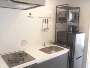 uma cozinha com um lavatório e um frigorífico preto em REVISION Kairouyama-tei - Vacation STAY 15800 em Hiroshima