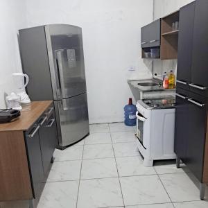 a kitchen with stainless steel appliances and a tile floor at Casa de praia in Sirinhaém