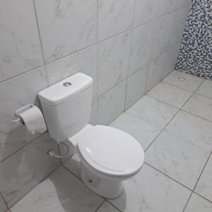 a bathroom with a white toilet and a shower at Casa de praia in Sirinhaém