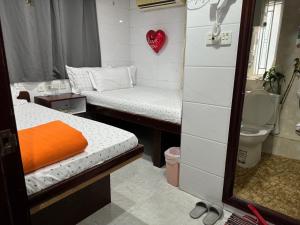 Habitación pequeña con 2 camas y aseo en Relaince lucky home, en Hong Kong