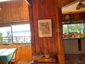 Casa y vista maravillosa, con piscina Coliumo Tomé في تومي: مطبخ مع طاولة ونوفذين في غرفة +6 صور