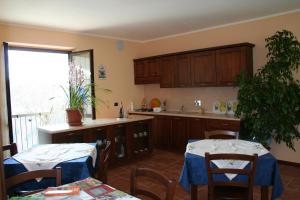a kitchen with wooden cabinets and two tables and chairs at Orchidea Selvatica B&B in Levice