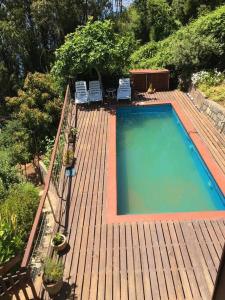 Casa y vista maravillosa, con piscina Coliumo Tomé في تومي: منظر علوي لحوض سباحة على سطح خشبي