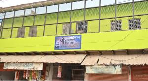 un edificio amarillo con un cartel en el costado en श्री बांके बिहारी सेवा धाम, en Vrindāvan