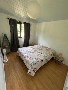 um quarto com uma cama com colcha floral em Casa Corsa à Moorea em Moorea